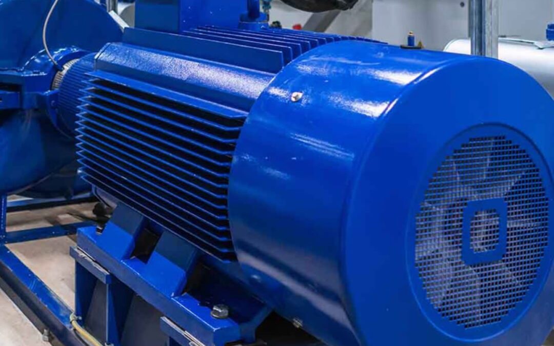Close-up of a large blue industrial electric motor installed in a facility, with the BM Industrial logo in the bottom right corner.